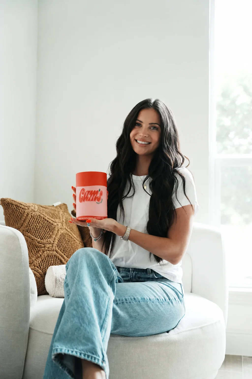 Camryn, founder of Cam's Fruit Snacks, smiling and holding the product canister