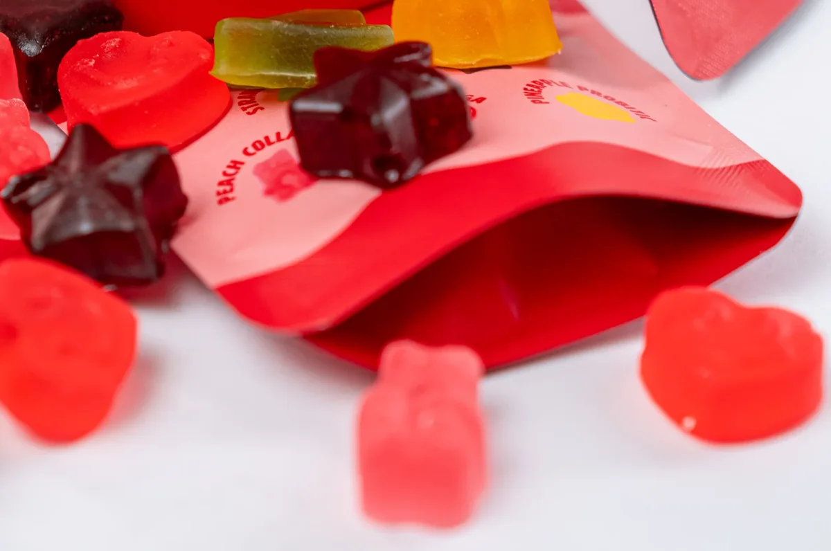 Open Cam's Fruit Snacks pouch surrounded by the five colorful gummy shapes